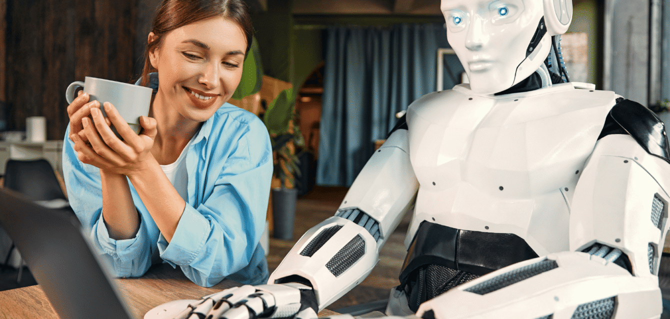 A smiling woman interacting with an AI-powered robot, illustrating WaveBNB’s automated guest chatbots for seamless Airbnb guest communication and support Smiling woman holding a coffee cup sits next to a humanoid AI robot, working together at a laptop in a cozy modern office setting.