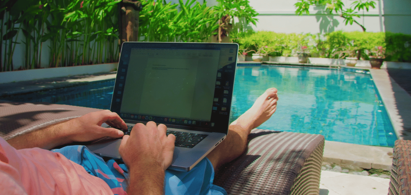 A remote worker optimizing an Airbnb listing on a laptop by the pool, representing WaveBNB’s expert SEO and listing optimization services for higher bookings Remote worker optimizing Airbnb listing by the pool with WaveBNB SEO services for higher bookings