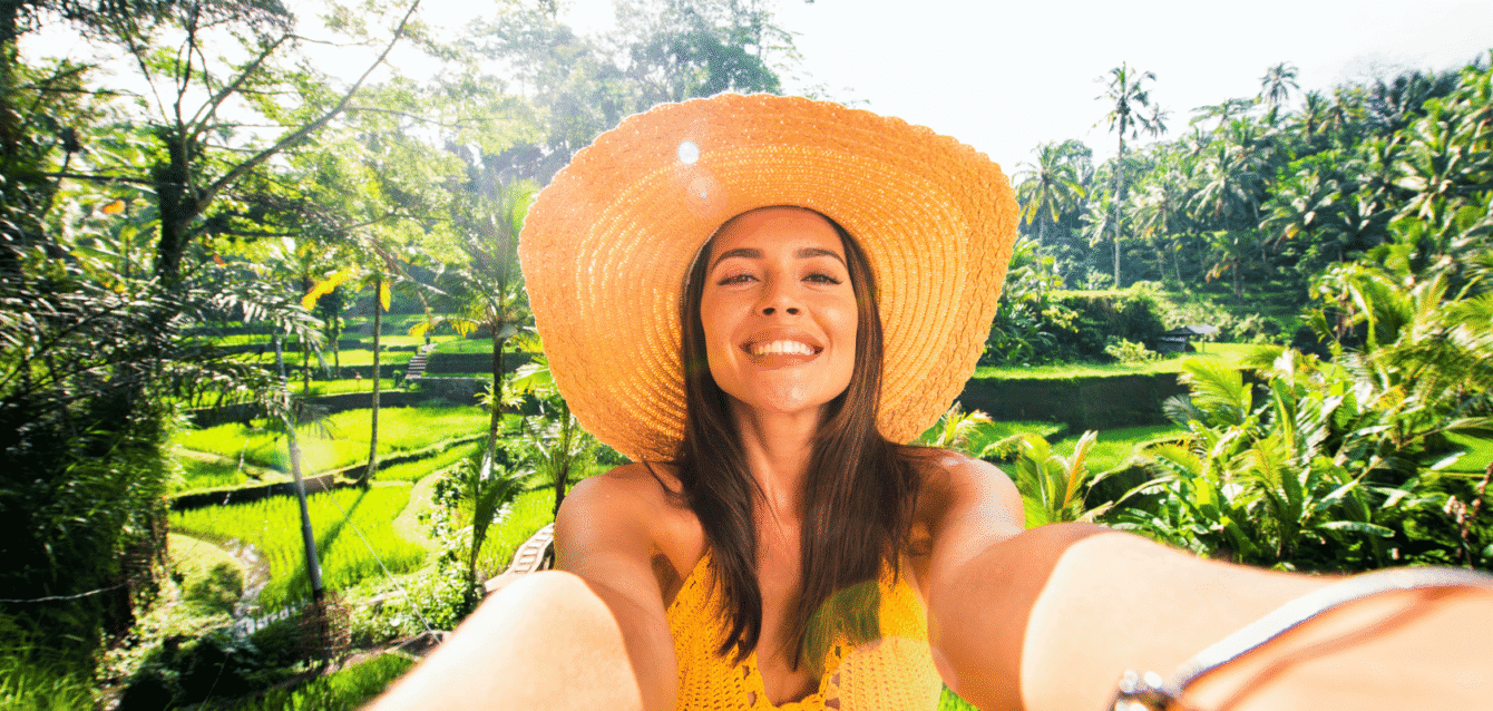 A smiling travel influencer taking a selfie in a tropical destination, representing WaveBNB’s Airbnb Influencer Strategy for boosting brand visibility and bookings Travel influencer taking selfie in tropical location to promote Airbnb stay