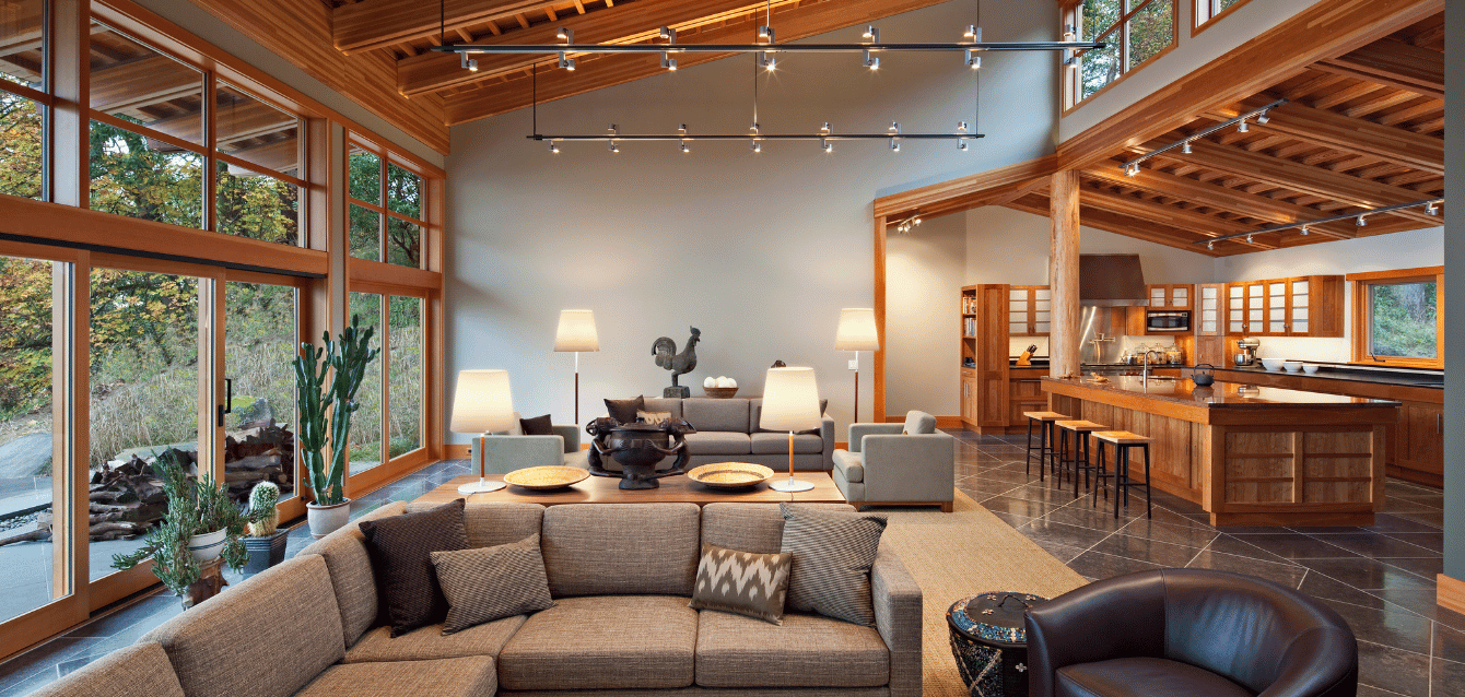Spacious open-concept luxury rental with floor-to-ceiling windows, elegant wood accents, and a modern kitchen—showcasing WaveBNB’s last-minute and long-stay discount automation strategies to incre