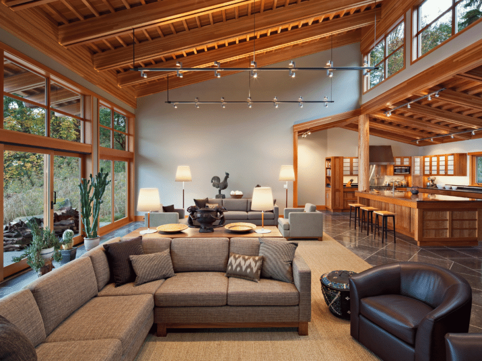 Spacious open-concept luxury rental with floor-to-ceiling windows, elegant wood accents, and a modern kitchen—showcasing WaveBNB’s last-minute and long-stay discount automation strategies to incre